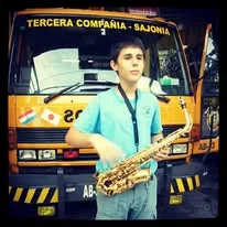 Joven saxofonista de Bandaliza posando frente a un móvil de la Tercera Compañía