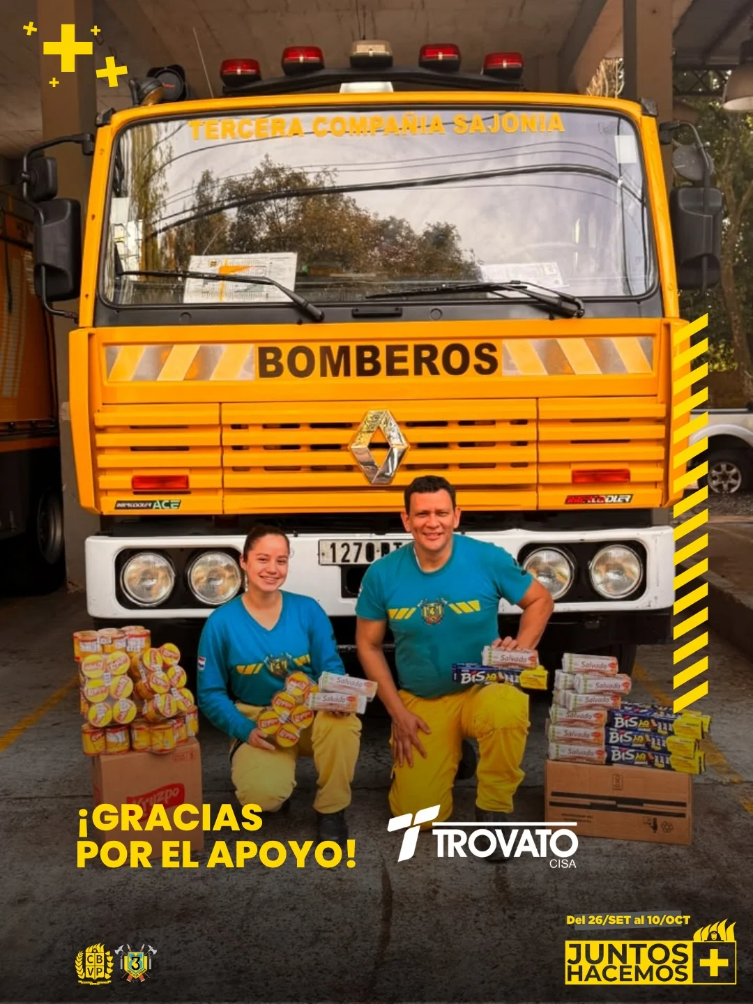 Dos voluntarios de K3 con donaciones frente a un móvil de bomberos